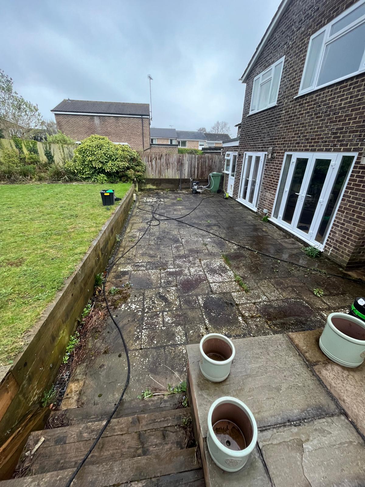 Patio before cleaning: paving covered in algae, moss and dark staining